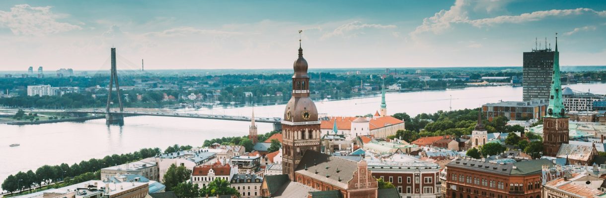 Riga, Latvia. Riga Cityscape Slyline In Sunny Summer Day. Famous Landmarks – Riga Dome Cathedral And Riga, Latvia. Riga Cityscape Slyline In Sunny Summer Day. Famous Landmarks - Riga Dome Cathedral And